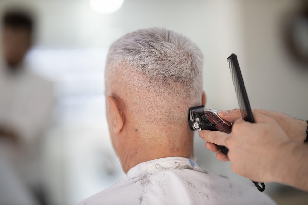 A barber running clippers up the back of a client's head