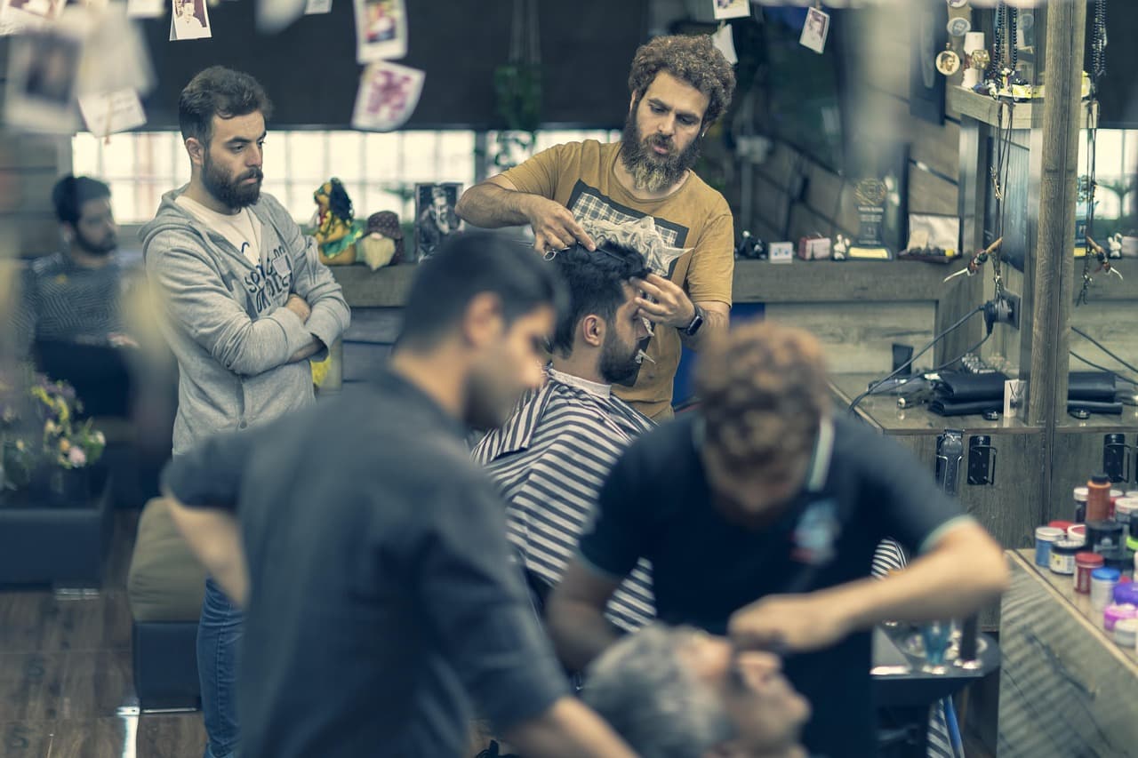 Barbers at work in a busy shop with clients waiting